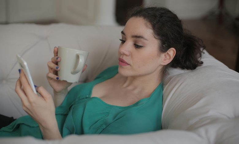 lady using phone and drinking coffee