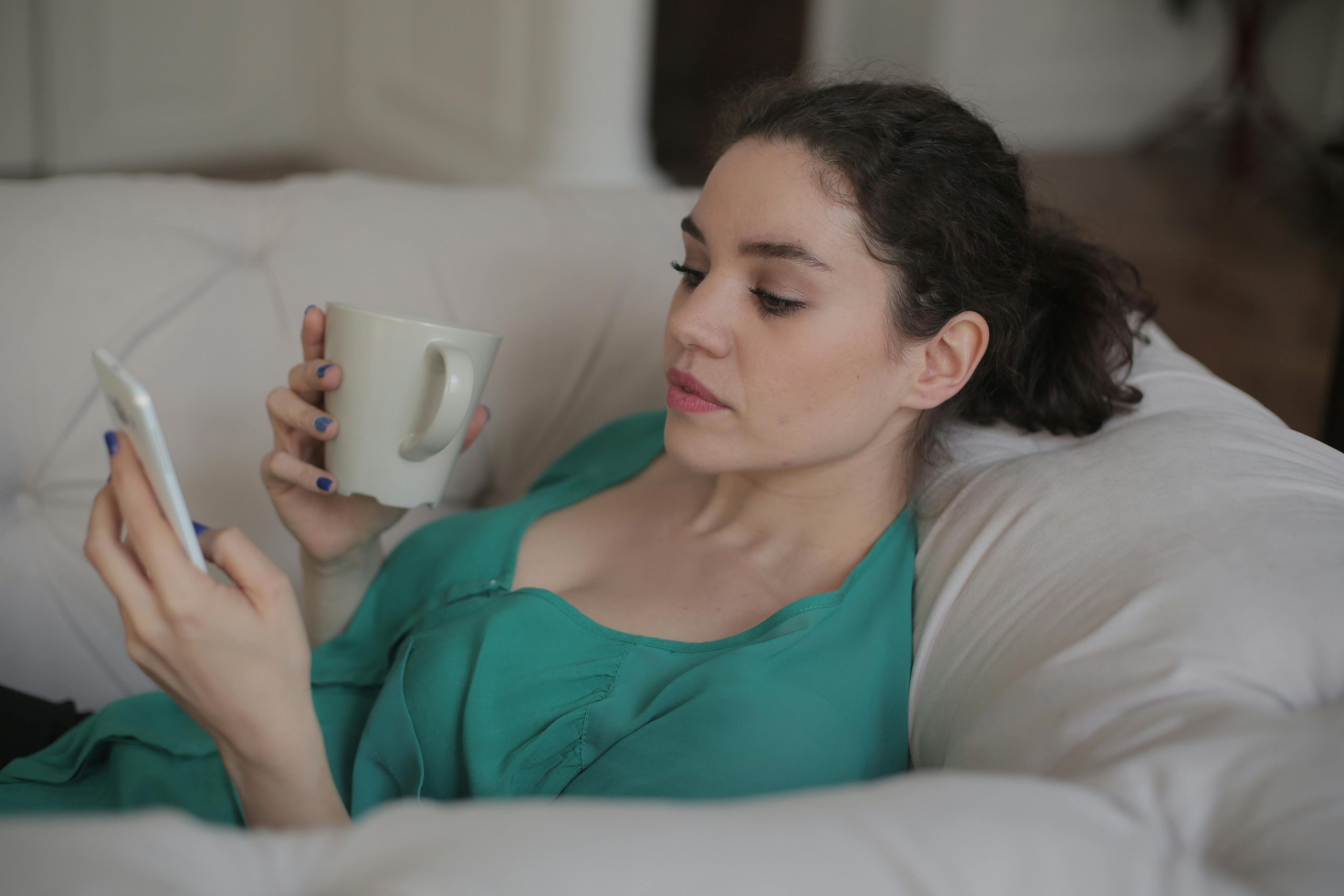 lady using phone and drinking coffee